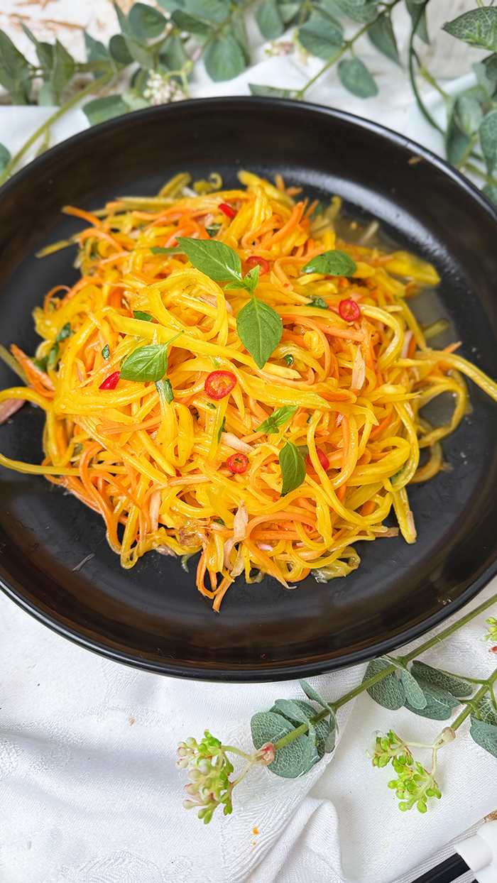 Thailändischer Mangosalat mit grünen Mangostreifen, Möhren und Chili