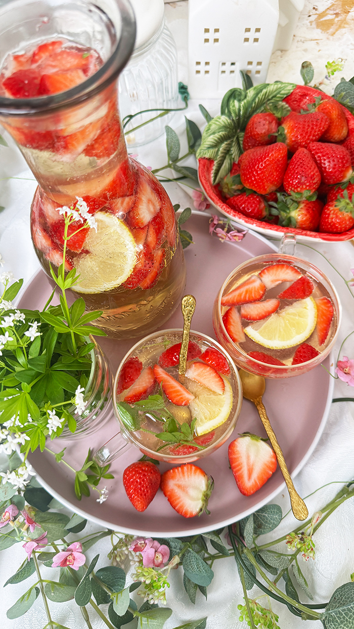 Selbstgemachte Maibowle mit Weißwein, Waldmeister und Sekt, dekoriert mit Zitronenscheiben