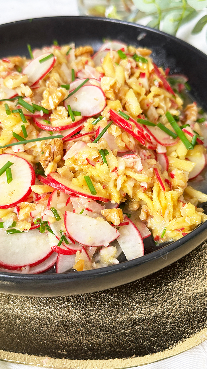 Radieschensalat mit Apfel und Walnüssen auf einen schwarzen Teller, Radieschensalat mit Apfel Rezept