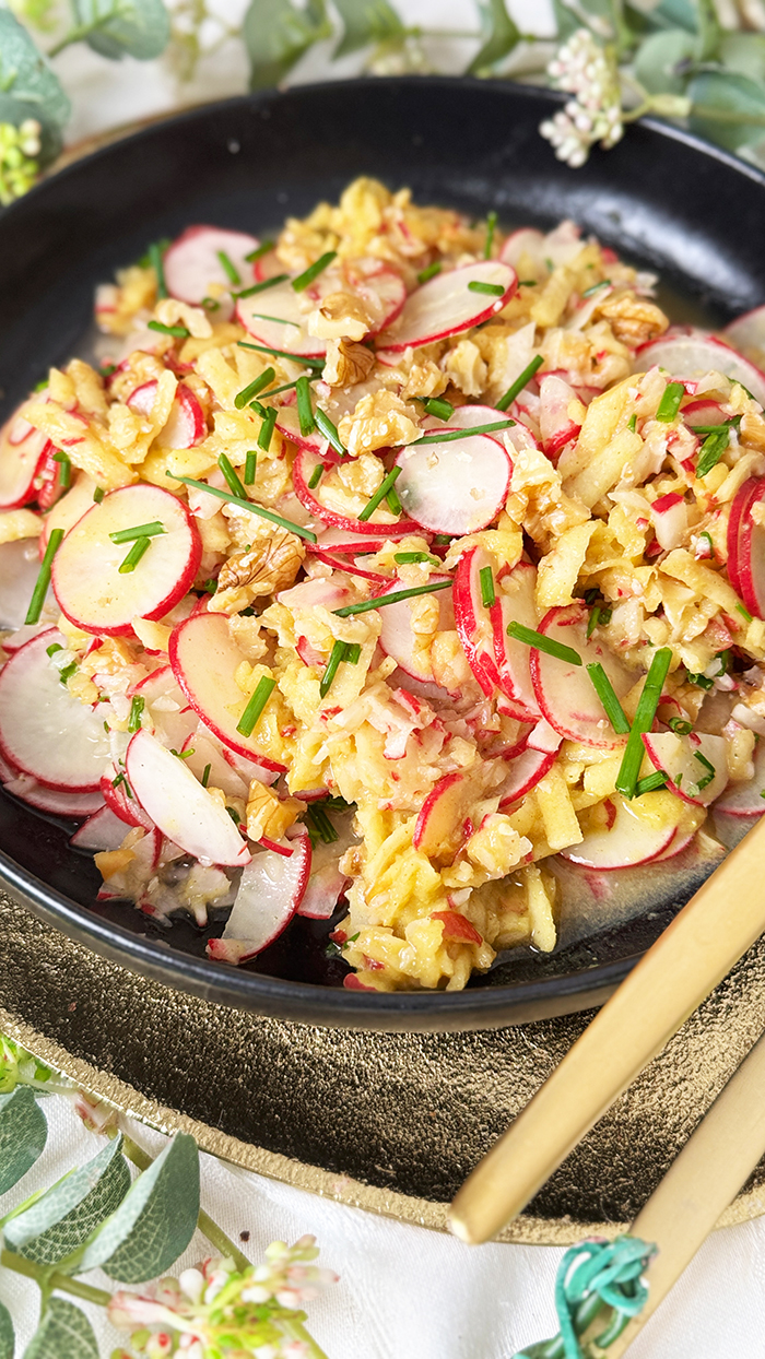 Radieschensalat mit Apfel und Walnüssen auf einen schwarzen Teller, Radieschensalat mit Apfel Rezept