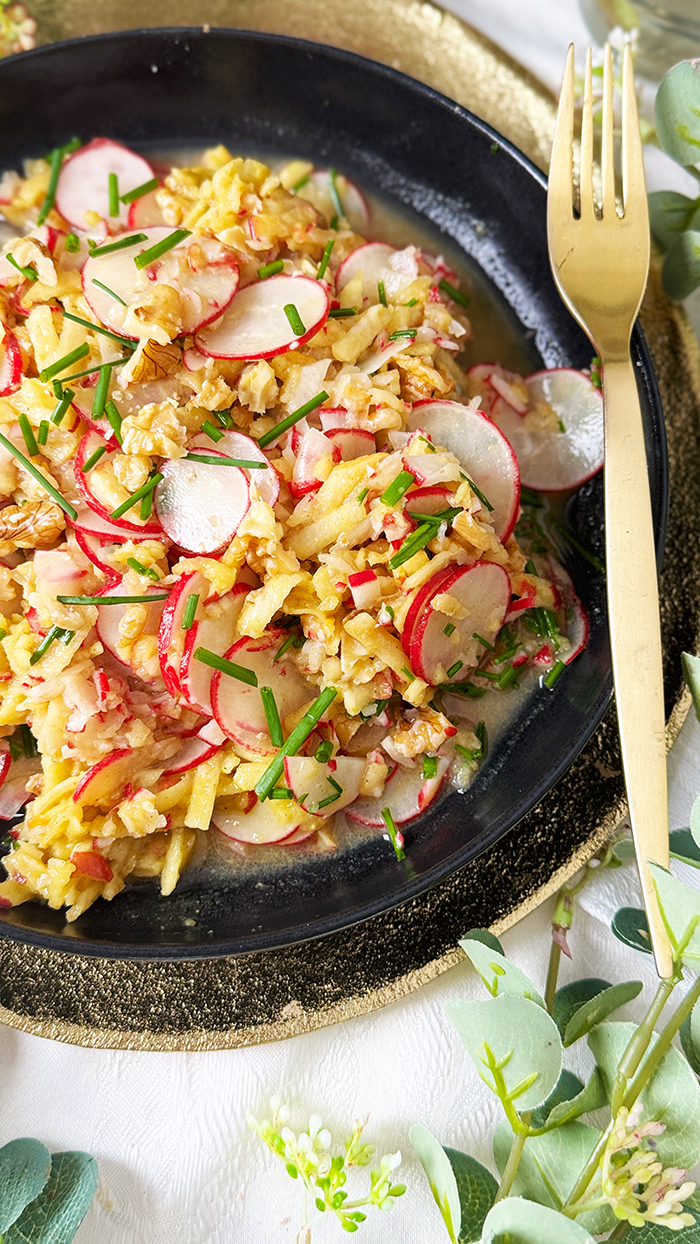 Radieschensalat mit Apfel und Walnüssen auf einen schwarzen Teller, Radieschensalat mit Apfel Rezept