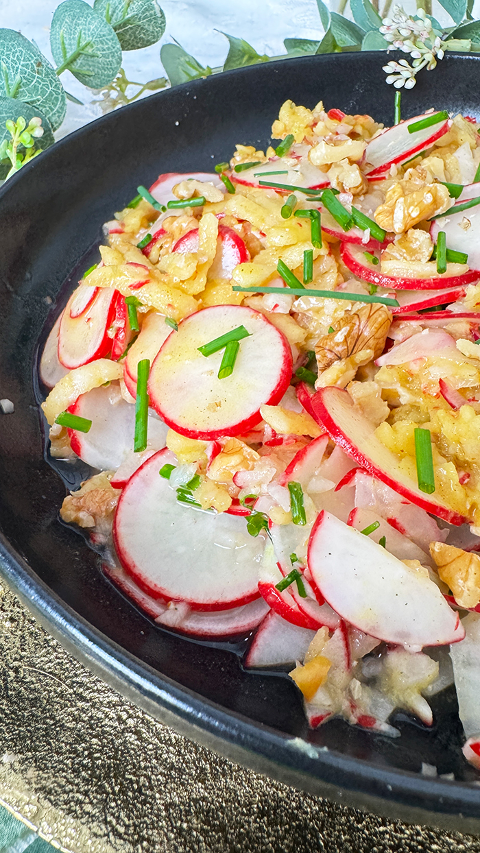 Radieschensalat mit Apfel und Walnüssen auf einen schwarzen Teller, Radieschensalat mit Apfel Rezept