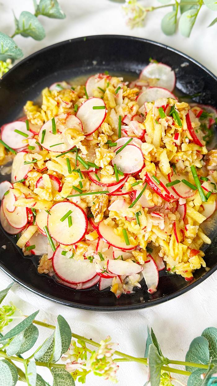 Radieschensalat mit Apfel und Walnüssen auf einen schwarzen Teller, Radieschensalat mit Apfel Rezept