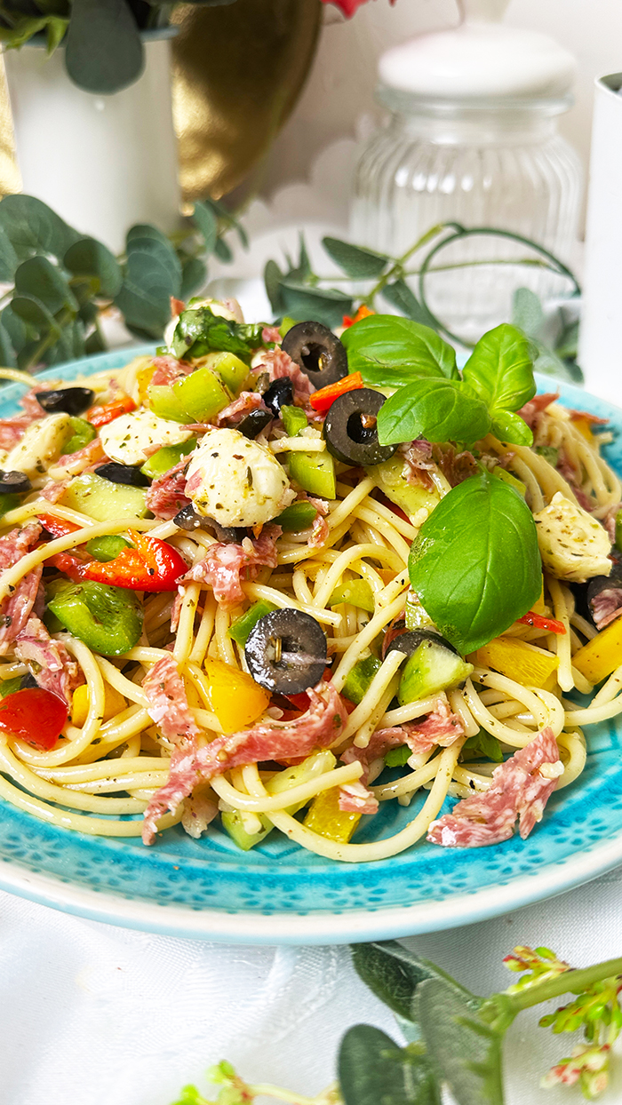 Spaghettisalat kalifornischer Art: bunter Nudelsalat mit Paprika, Mozzarella, Salami, Oliven und frischen Kräutern