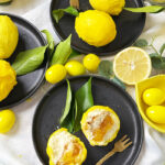 Cedric Grolet Zitronen mit Lemon Curd, Mascarponecreme und Plätzchenboden, angerichtet mit frischen Zitronenblättern.
