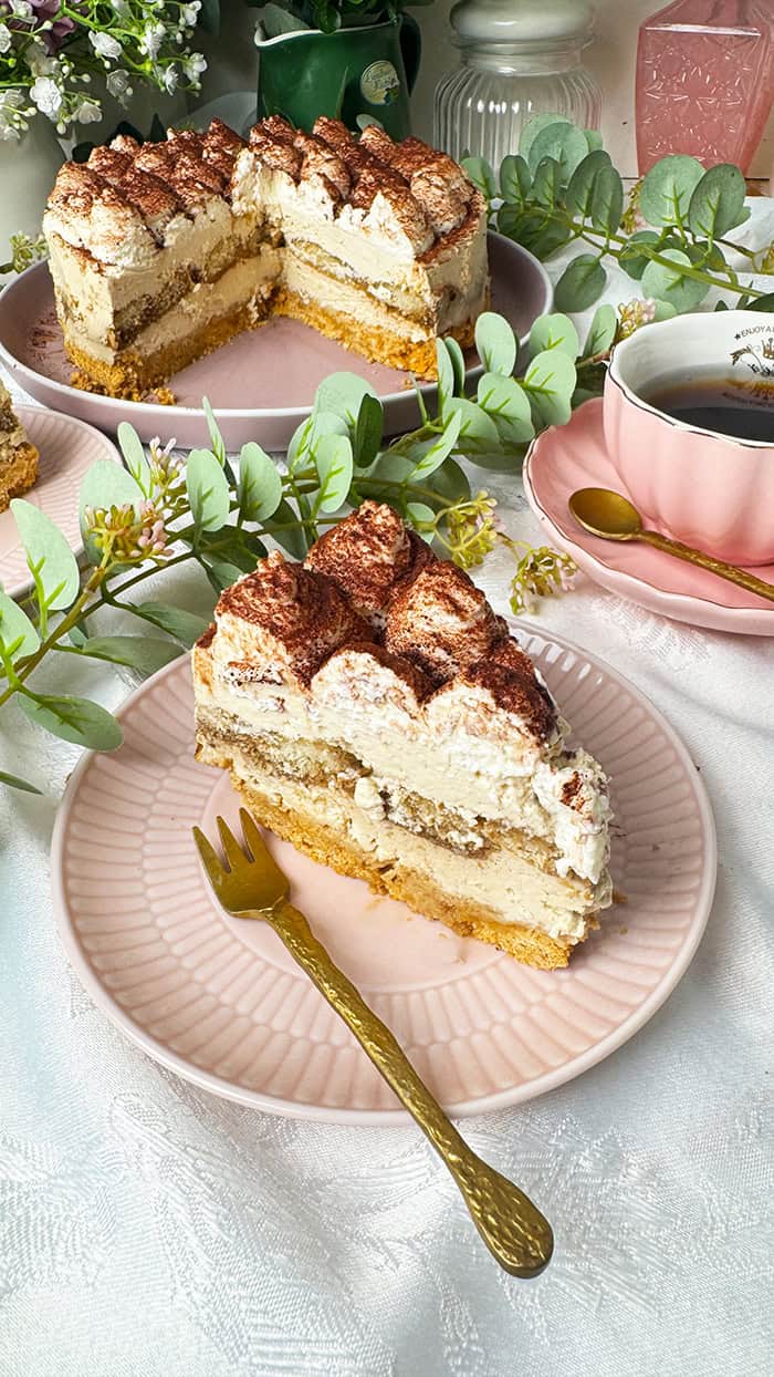 Tiramisu-Torte ohne Backen mit Mascarponecreme und Kakaopulver, umgeben von Blumen. Tiramisu-Torte ohne Backen mit Mascarponecreme und Kakaopulver, umgeben von Blumen.