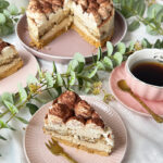 Tiramisu-Torte ohne Backen mit Mascarponecreme und Kakaopulver, umgeben von Blumen.