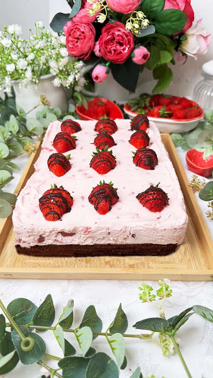 Ein Erdbeeren-Schoko-Kuchen vom Blech mit cremiger Erdbeer-Joghurt-Sahne und frischen Erdbeeren auf einem saftigen Schokobiskuitboden, dekoriert mit Schoko-Erdbeeren 