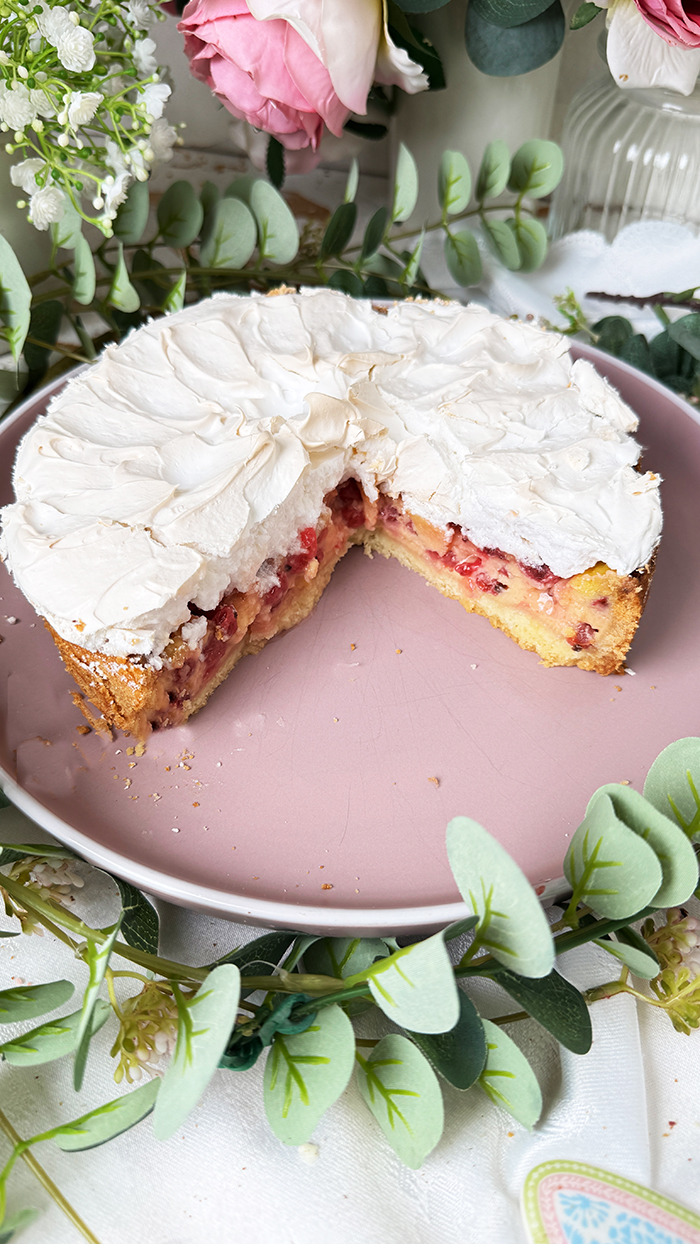 Johannisbeerkuchen mit Baiser auf einer Kuchenplatte serviert