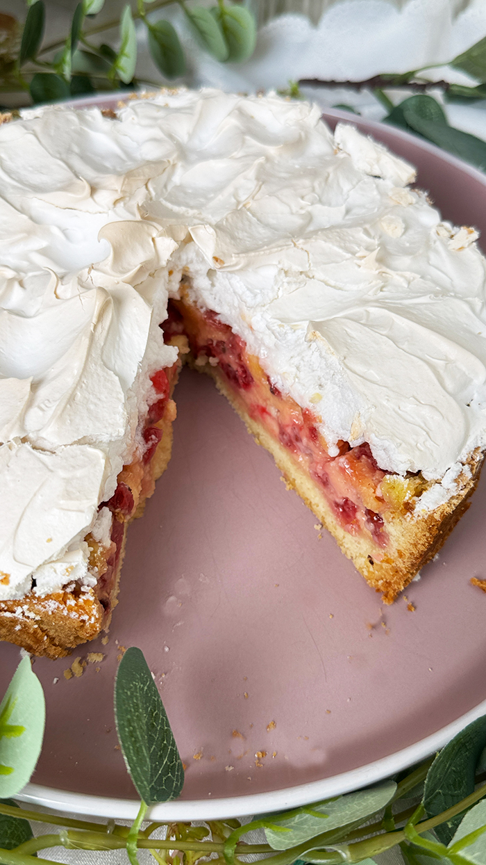 Johannisbeerkuchen mit Baiser auf einer Kuchenplatte serviert