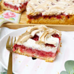 Johannisbeerkuchen mit Baiser vom Blech, in Stücke geschnitten, mit frischen Beeren und Kaffee serviert.