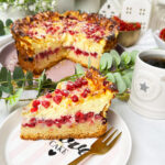 Ein Johannisbeerkuchen mit Mascarponecreme und goldbraunem Mandel-Crunch auf einem Teller, ein Kuchen mit Mandeln und Johannisbeeren
