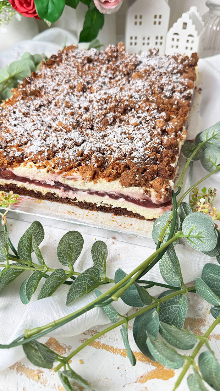 Ein Stück Kirsch-Streuselkuchen mit Creme vom Blech 