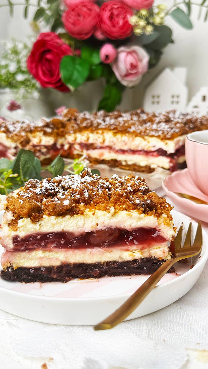 Ein Stück Kirsch-Streuselkuchen mit Creme vom Blech 