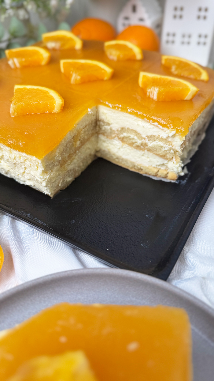 Cremiges Solero-Tiramisu mit Maracujaspiegel und Orangendeko – frisches Sommerdessert auf einem Teller servier