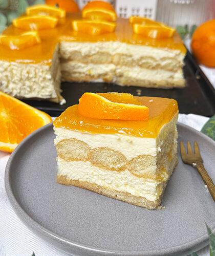 Solero-Tiramisu Rezept: 5 Gründe, warum es dein bester Dessert Sommerhit wird 1 Ein Stück Solero-Tiramisu mit heller Creme, getränkten Löffelbiskuits und fruchtigem Maracujaspiegel, dekoriert mit frischer Orangenscheibe, serviert auf einem grauen Teller – ein sommerliches Dessert ohne Backen.