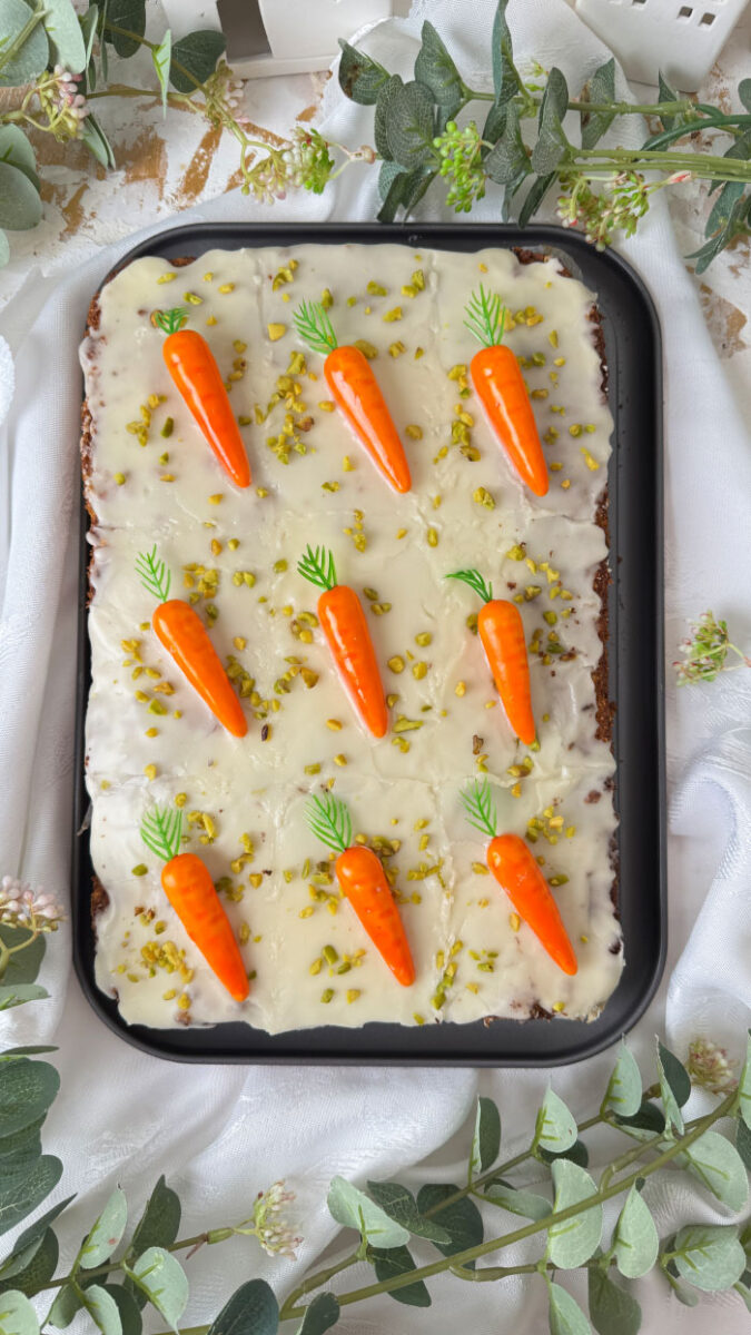 Schweizer Rüblikuchen: Das Original-Rezept für den einfachen saftigen Klassiker 2 Schweizer Rüblikuchen mit weißem Zuckerguss, Pistazien und Marzipanrüben