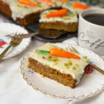 Saftiges Stück Schweizer Rüblikuchen mit weißem Zuckerguss, Pistazien und einer Marzipanr