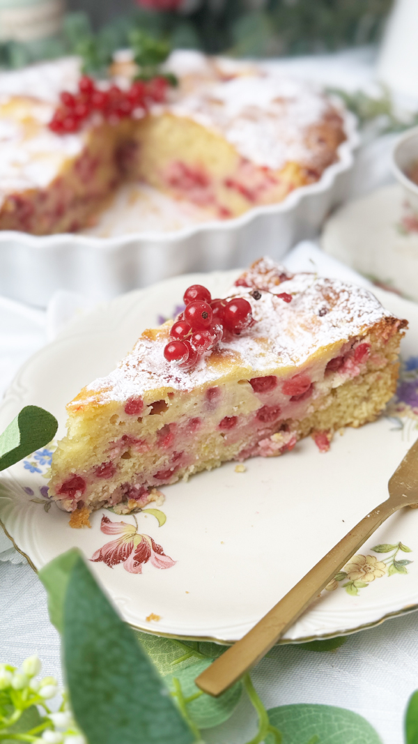 Johannisbeerkuchen mit Schmand, saftig und einfach 1 Johannisbeerkuchen mit Schmand auf einem Teller, saftiger Rührkuchen mit roten Johannisbeeren und cremigem Schmand Swirl, mit Puderzucker bestäubt.
