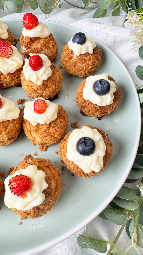 Choux au Craquelin mit Vanillecreme, knusprig & cremig 2 Choux au Craquelin mit Vanillecreme und frischen Erdbeeren und Heidelbeeren auf einem Teller