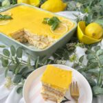Cremiges Zitronen-Tiramisu mit selbst gemachtem Lemon Curd, Mascarpone-Sahne-Creme und in Zitronensirup getränkten Löffelbiskuits. Ein frisches Sommerdessert ohne Backen, dekoriert mit Zitronenscheiben und Basilikum.