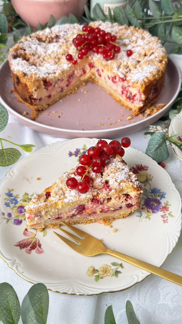 Johannisbeerkuchen mit Quark und Streuseln, cremig & fruchtig 2 Johannisbeerkuchen mit Quark und Streuseln, angeschnitten mit einem Kuchenstück und frischen roten Johannisbeeren