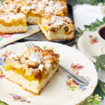 Mirabellenkuchen mit Honigstreuseln und frischen Marillen auf einem Teller