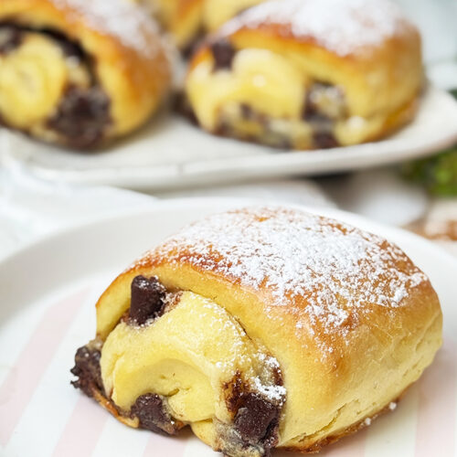 Einen Teller mit Ein Teller mit Blätterteig-Schnitten mit Nutella und Banane und Puderzucker