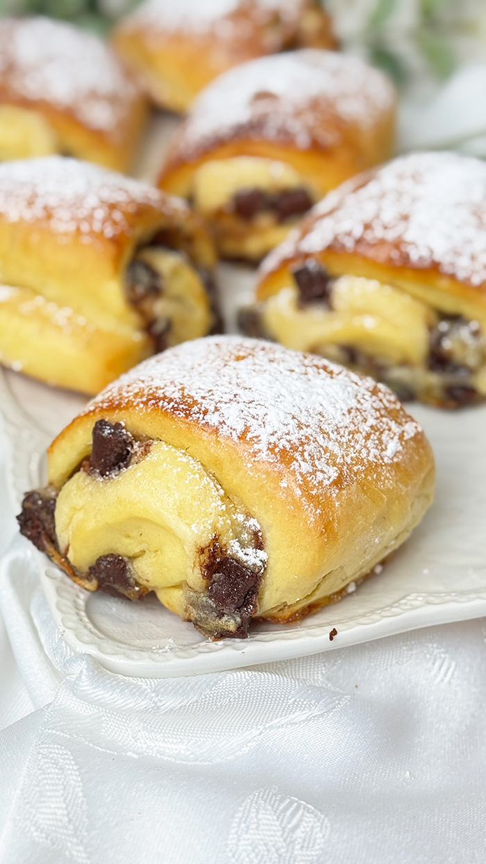 Einen Teller mit Ein Teller mit Blätterteig-Schnitten mit Nutella und Banane und Puderzucker