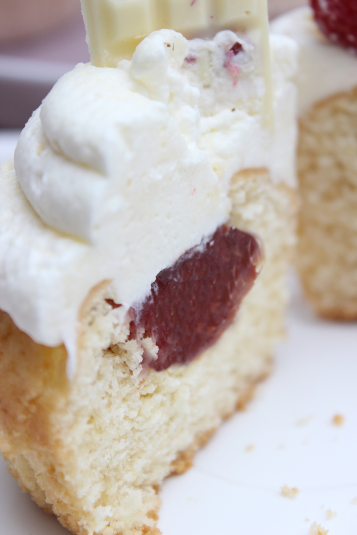 Himbeer-cupcakes mit vanille-frosting mit marmetube