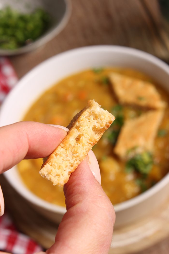 Zwiebel abziehen, fein würfeln. Suppengrün waschen, putzen und in 5 mm  große Würfel schneiden. Lauch in feine Ringe schneiden. Butternutkürbis waschen, putzen, schälen und in 1 cm große Stücke schneiden. Kartoffeln, schälen, waschen, trocken tupfen, ebenfalls in 1 cm groß würfeln. Öl in einen großen Topf (5 Liter) erhitzen. Zwiebeln und kleingeschnittenes Suppengemüse darin ca. 5 Minuten andünsten. Kürbis und Kartoffeln zugeben, kurz mitdünsten. Mit der Gemüsebrühe aufgießen, alles bei kleiner Hitze 20 Minuten köcheln lassen. Etwa die Hälfte des Eintopfes herausnehmen und fein pürieren, wieder dazugeben. Kürbiseintopf mit Salz, Pfeffer, Muskat abschmecken. Für die Käseecken den Ofen auf 180 Grad vorheizen. Eier trennen. Eiweiß mit einer Prise Salz steif schlagen. Butter schaumig rühren, Eigelbe, Käse, Semmelbrösel, Salz und Muskat einrühren. Eischnee unterheben. Masse fingerdick auf ein mit Backpapier belegtes Backblech streichen. Masse im Ofen 15 Minuten backen. Herausnehmen und in Rauten schneiden. Kürbiseintopf mit Käseecken anrichten, mit Petersilie bestreut servieren.