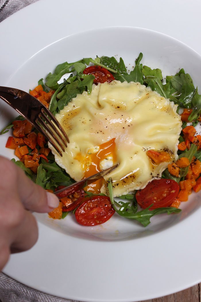 Riesen Ravioli mit Ricotta-Kräuter Füllung, Eigelb, garniert mit Rucula, Kürbis, Ofentomaten & Salbeibutter
